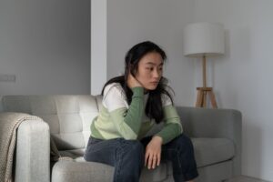 sad depressive korean woman sitting on sofa thinki 2023 11 27 05 07 22 utc 1
